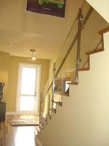 A staircase with a glass railing in a hallway