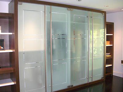 A room with a lot of glass doors and shelves.