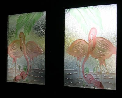 Two paintings of flamingos are hanging on a wall.