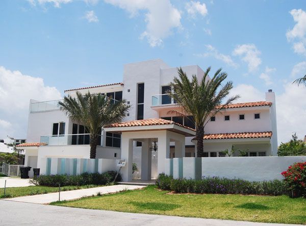 A large white house with palm trees in front of it.