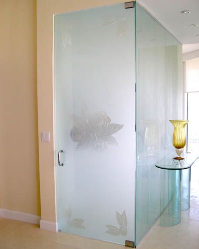 A glass door with a vase on a table in a room.