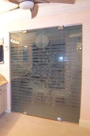 A bathroom with a glass door and a ceiling fan.