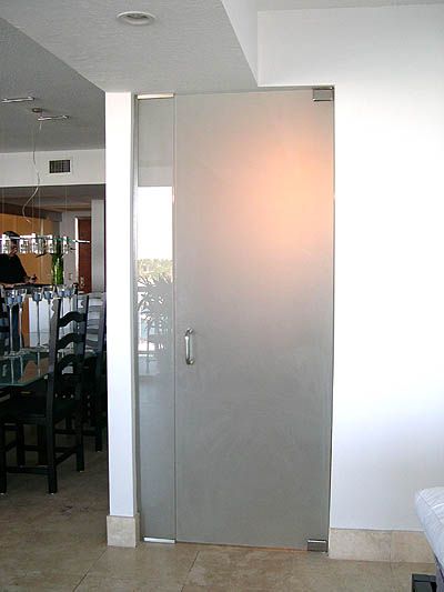 A glass door in a room with a dining room in the background