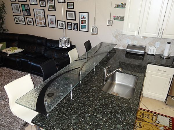 A kitchen with granite counter tops and a stainless steel sink