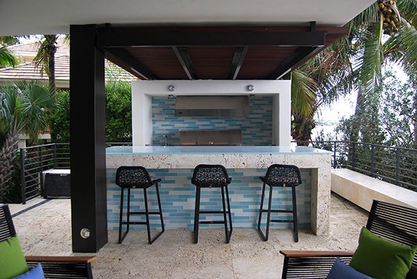 A patio with a bar and three stools
