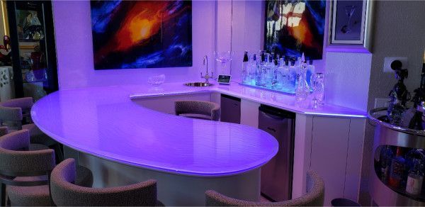 A bar with a purple counter top and chairs