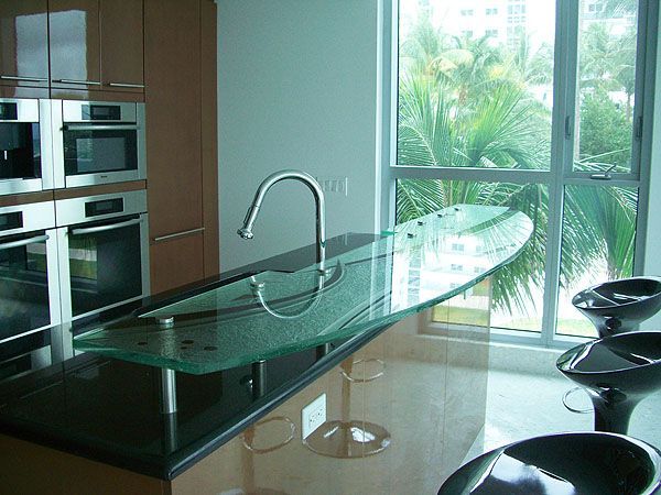 A kitchen with stainless steel appliances and a glass counter top