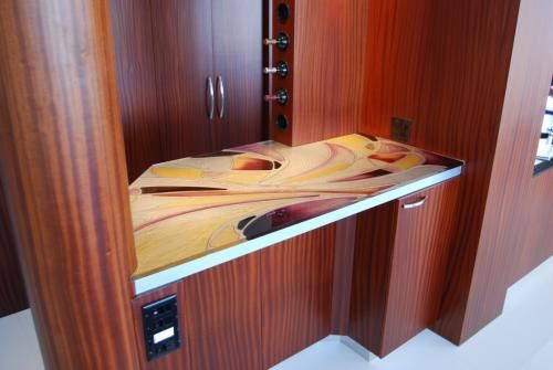A wooden cabinet with a glass counter top in a kitchen.