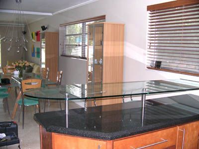 A kitchen with a glass table and a black counter top