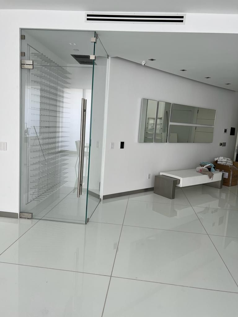 A living room with a glass door and a mirror on the wall.