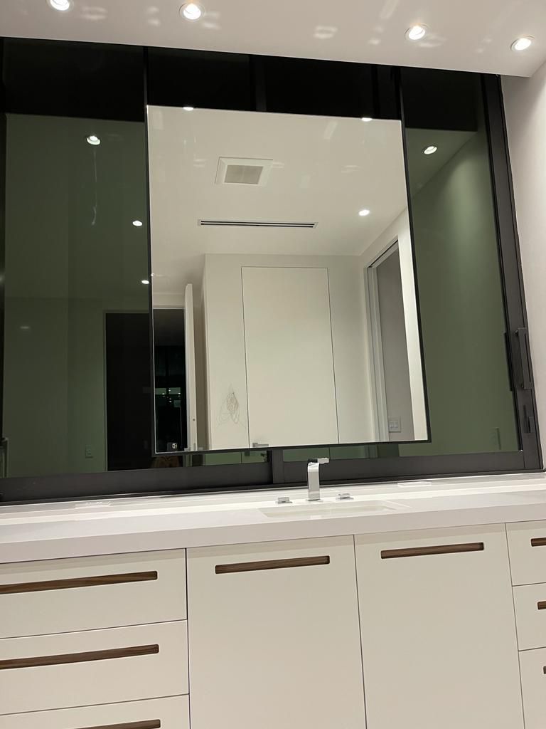 A bathroom with a large mirror and a sink