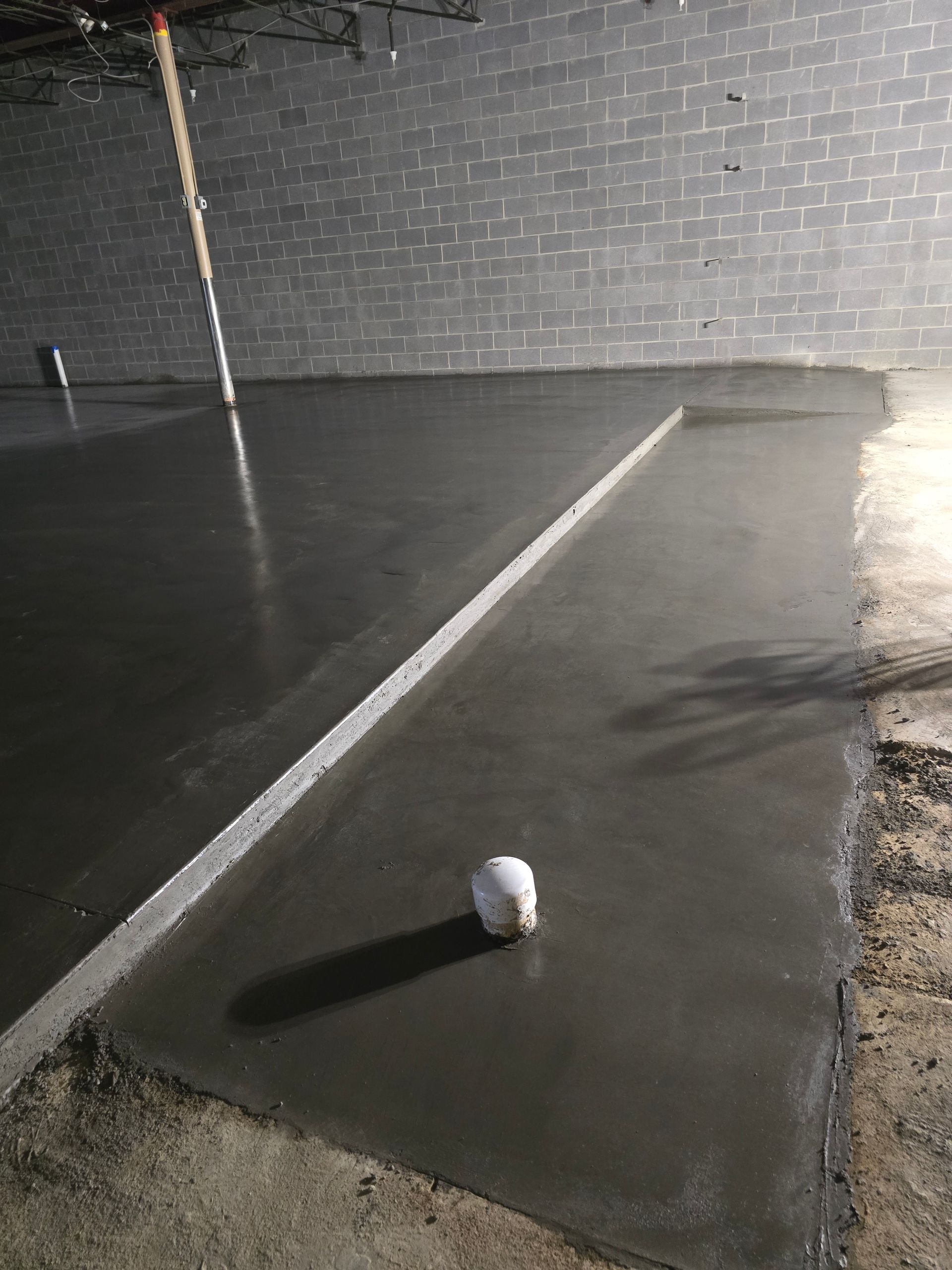 A baseball is sitting on top of a concrete floor.