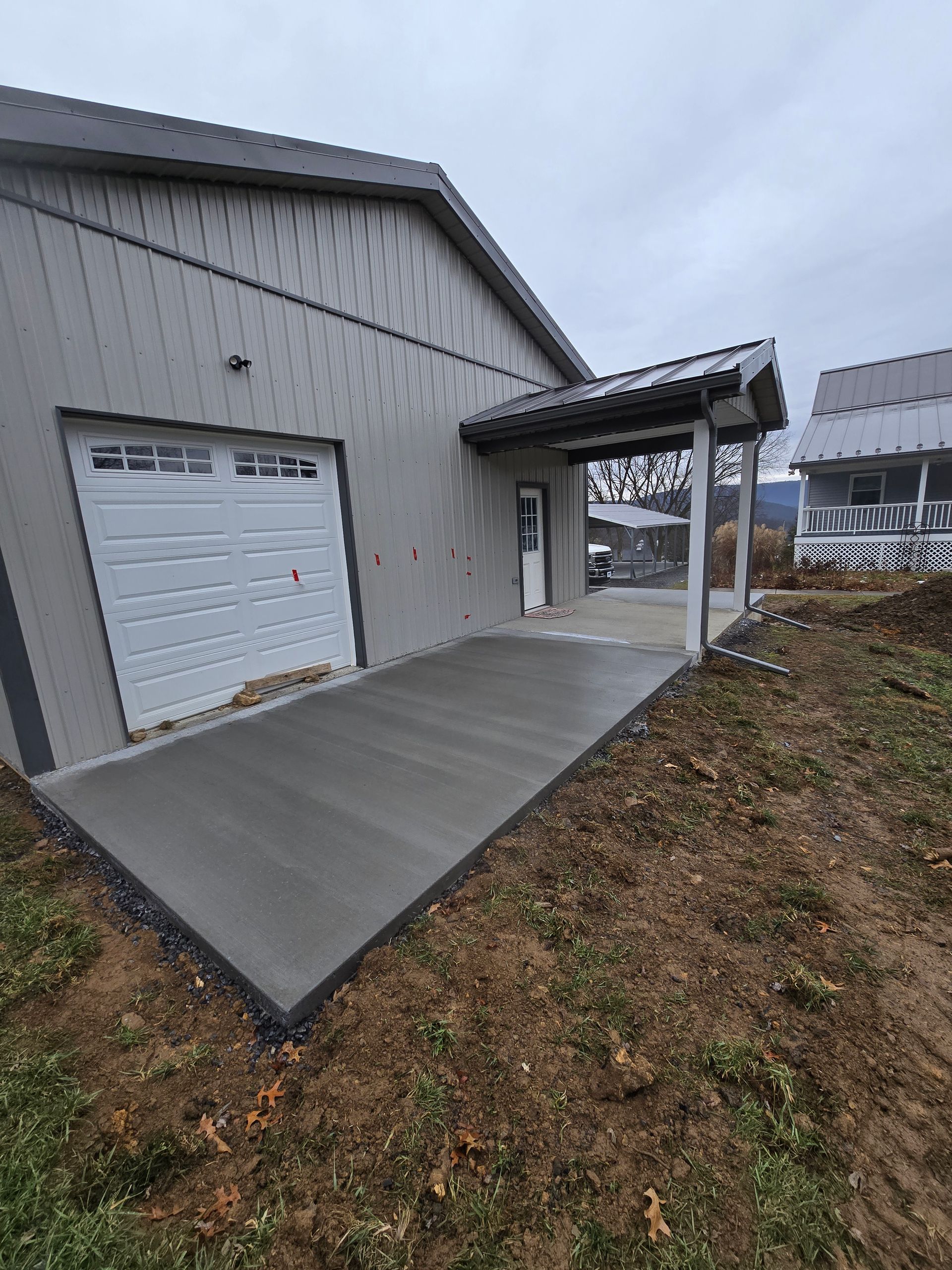 A garage with a concrete driveway in front of it.