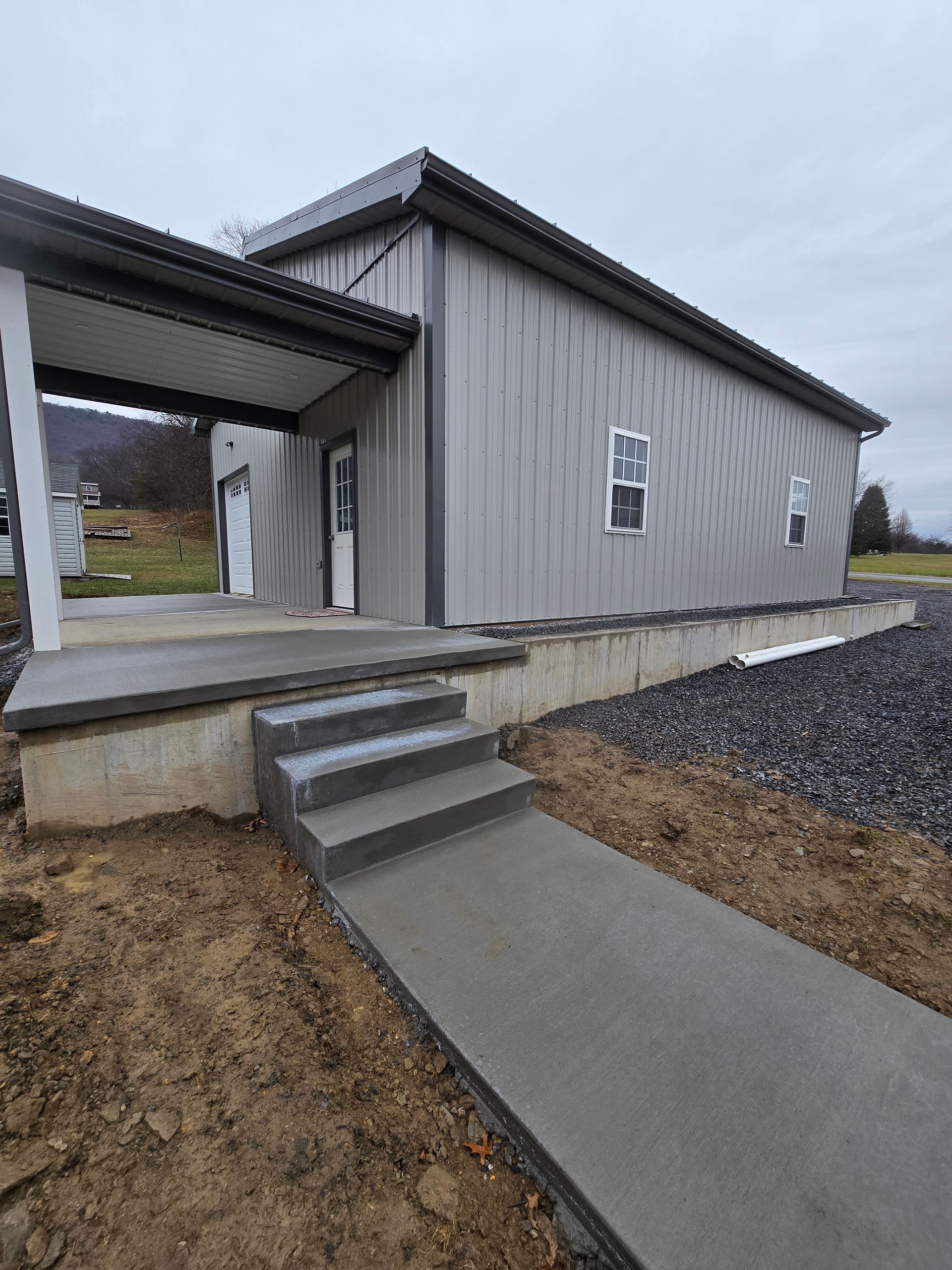 There is a concrete walkway leading to the front of the house.
