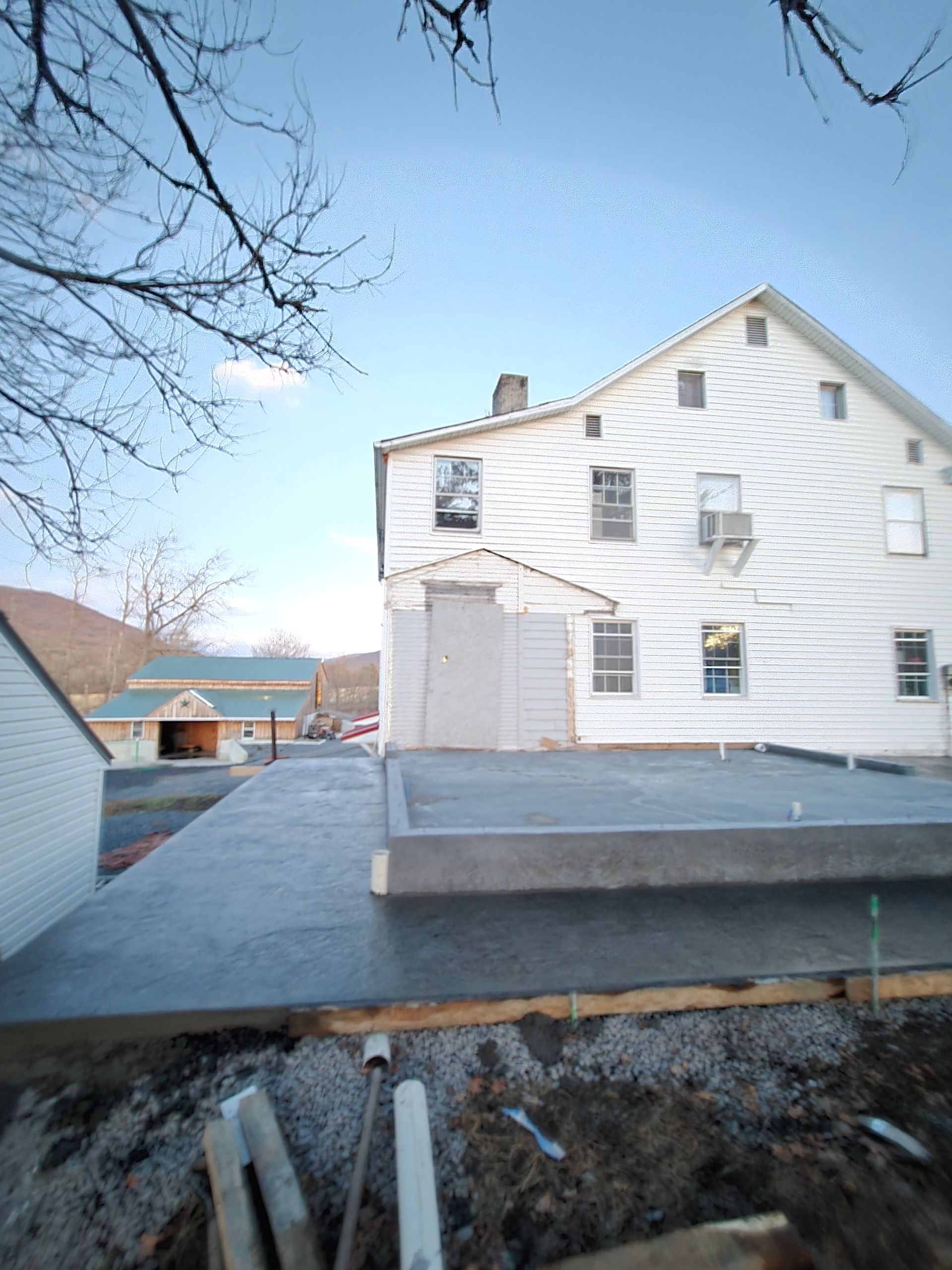 A large white house with a concrete walkway in front of it.