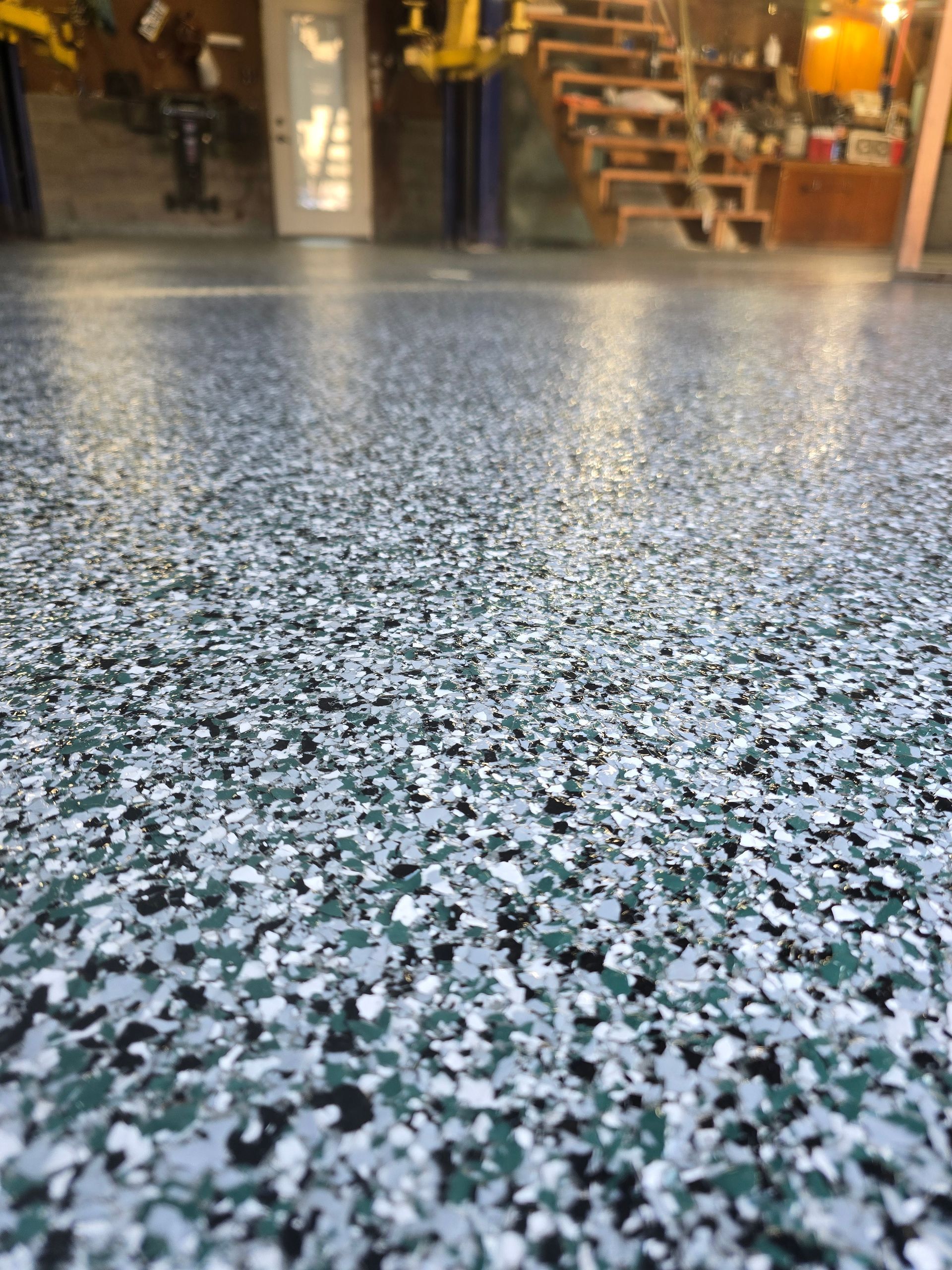 A close up of a concrete floor with a staircase in the background.