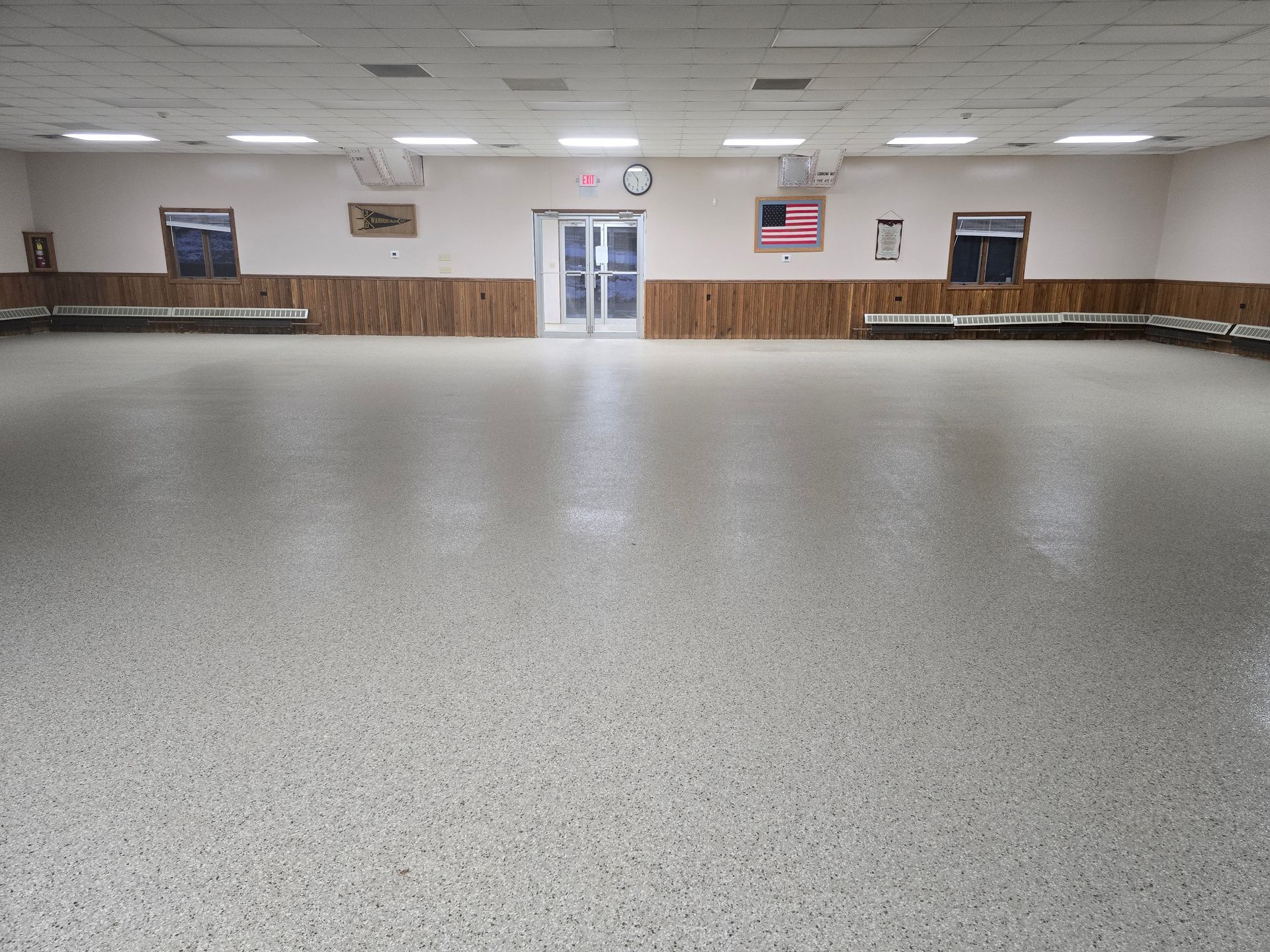 A large empty room with a flag on the wall.