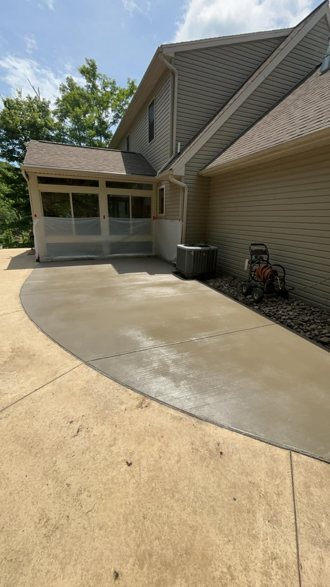 A concrete driveway leading to a house with a garage.
