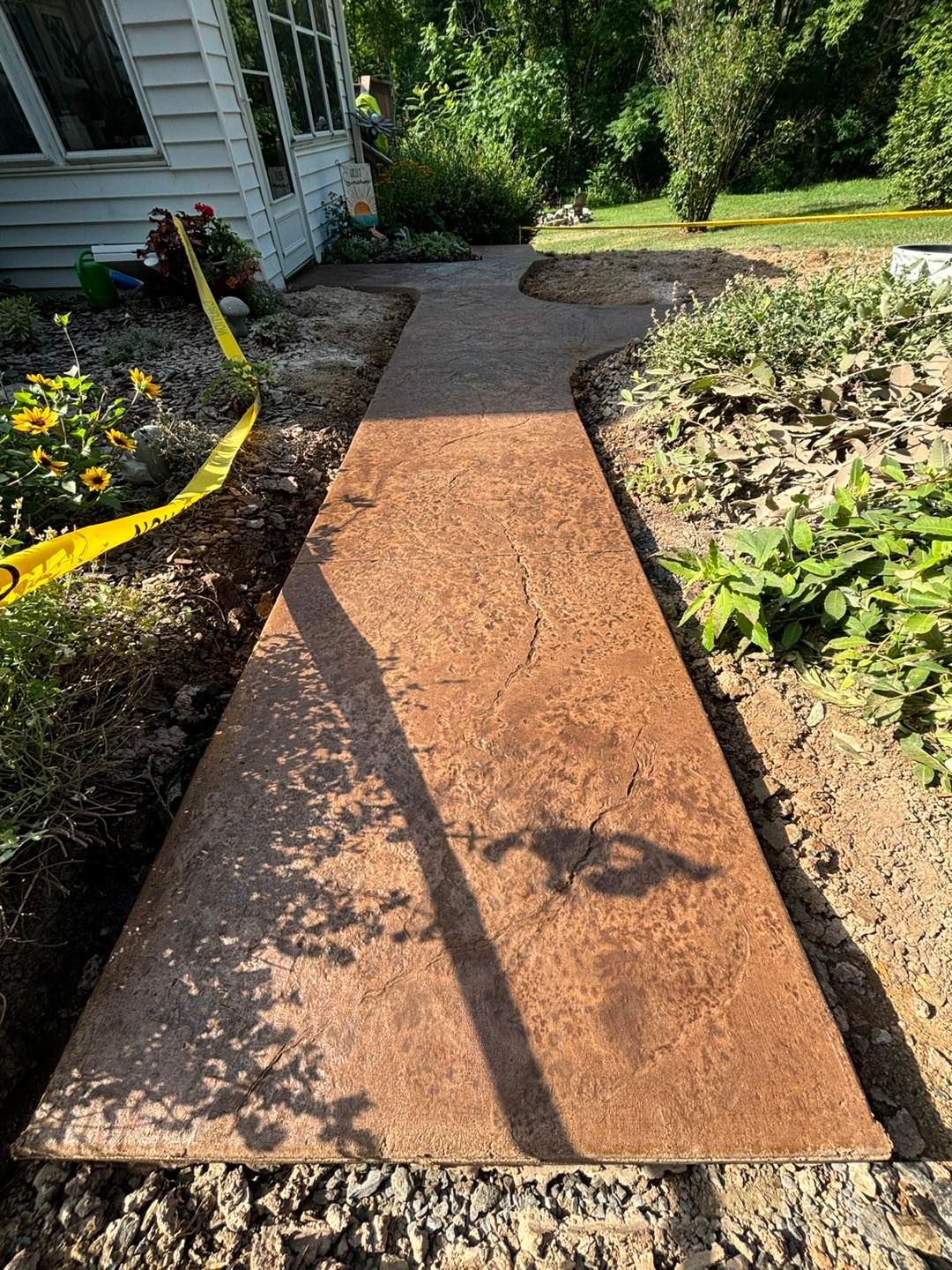 A concrete walkway is being built in front of a house.