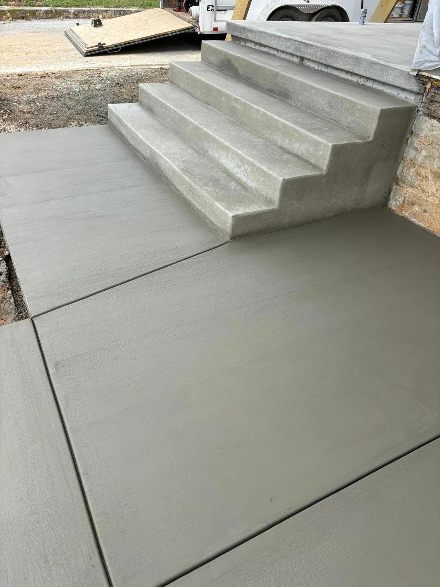 A person is standing next to a set of concrete stairs.