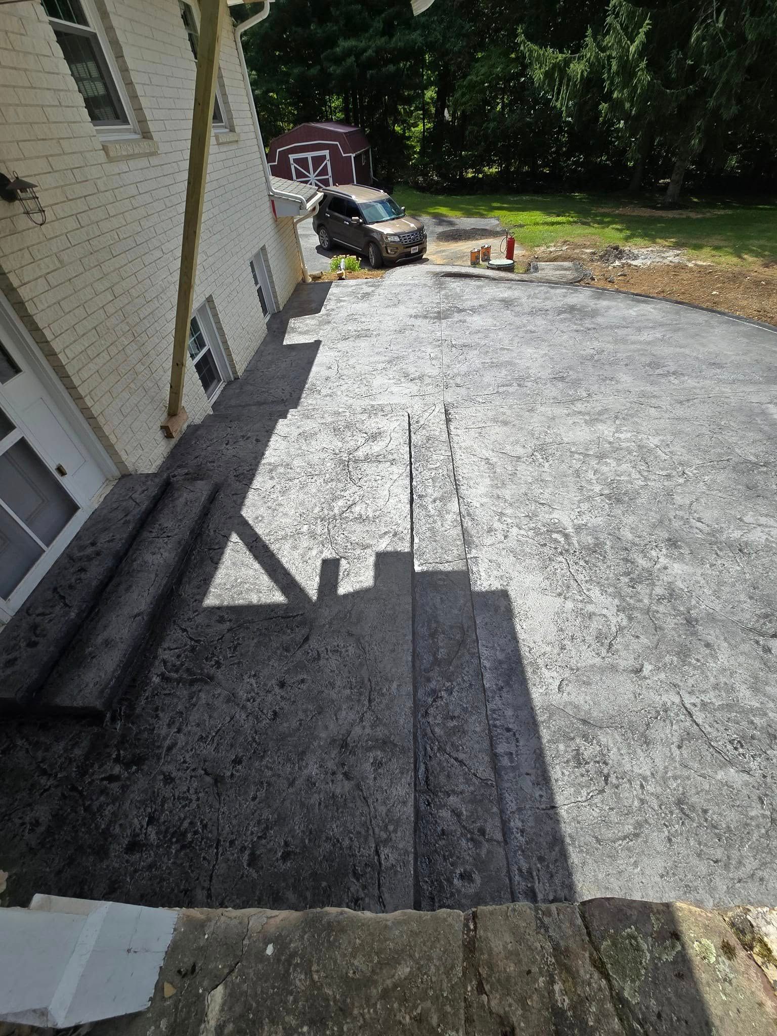 A car is parked in a driveway next to a house.