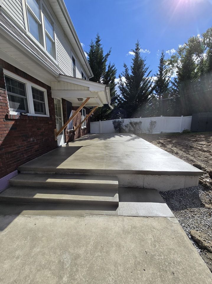 A brick house with a concrete patio in front of it.