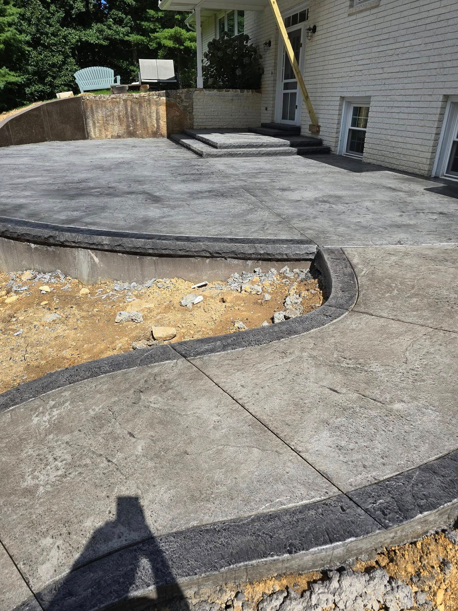 A concrete patio is being built in front of a house.