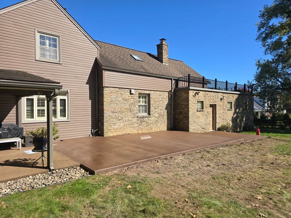 A large house with a concrete patio in front of it.