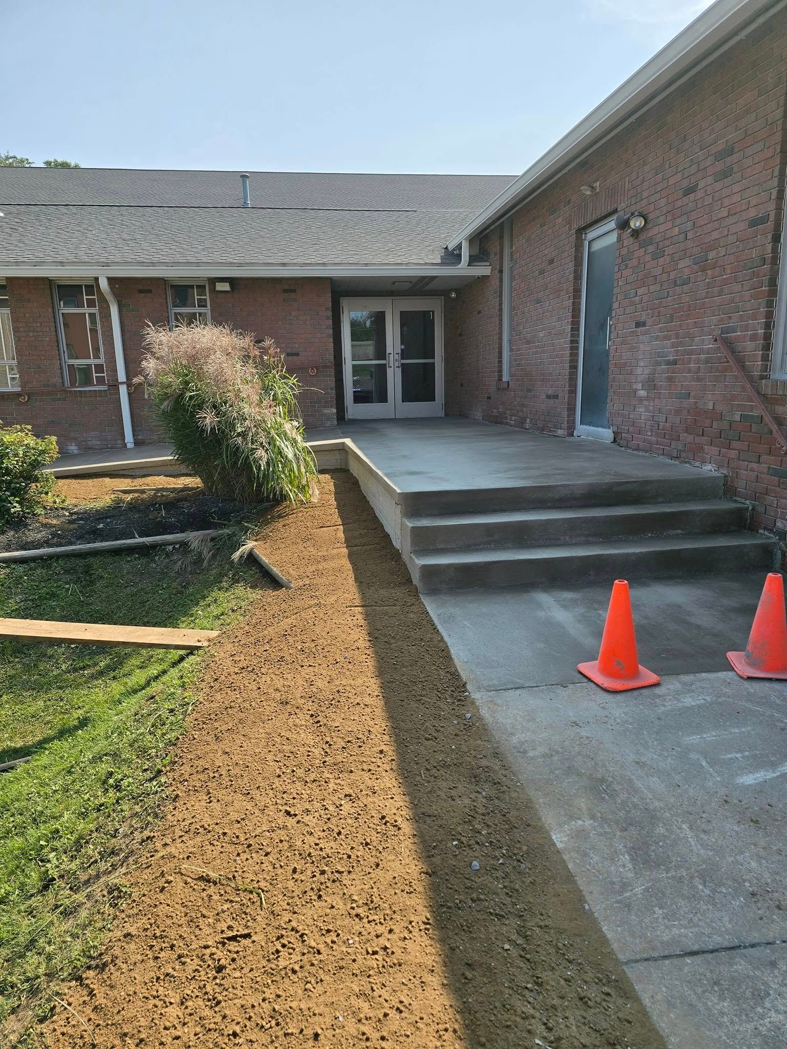 A brick building with a concrete walkway leading to it.