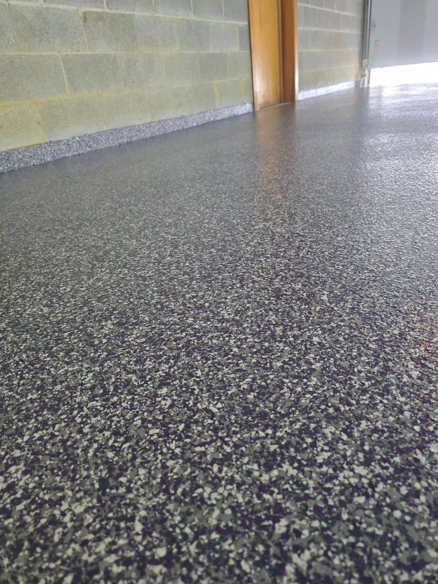 A close up of a black and white concrete floor in a garage.