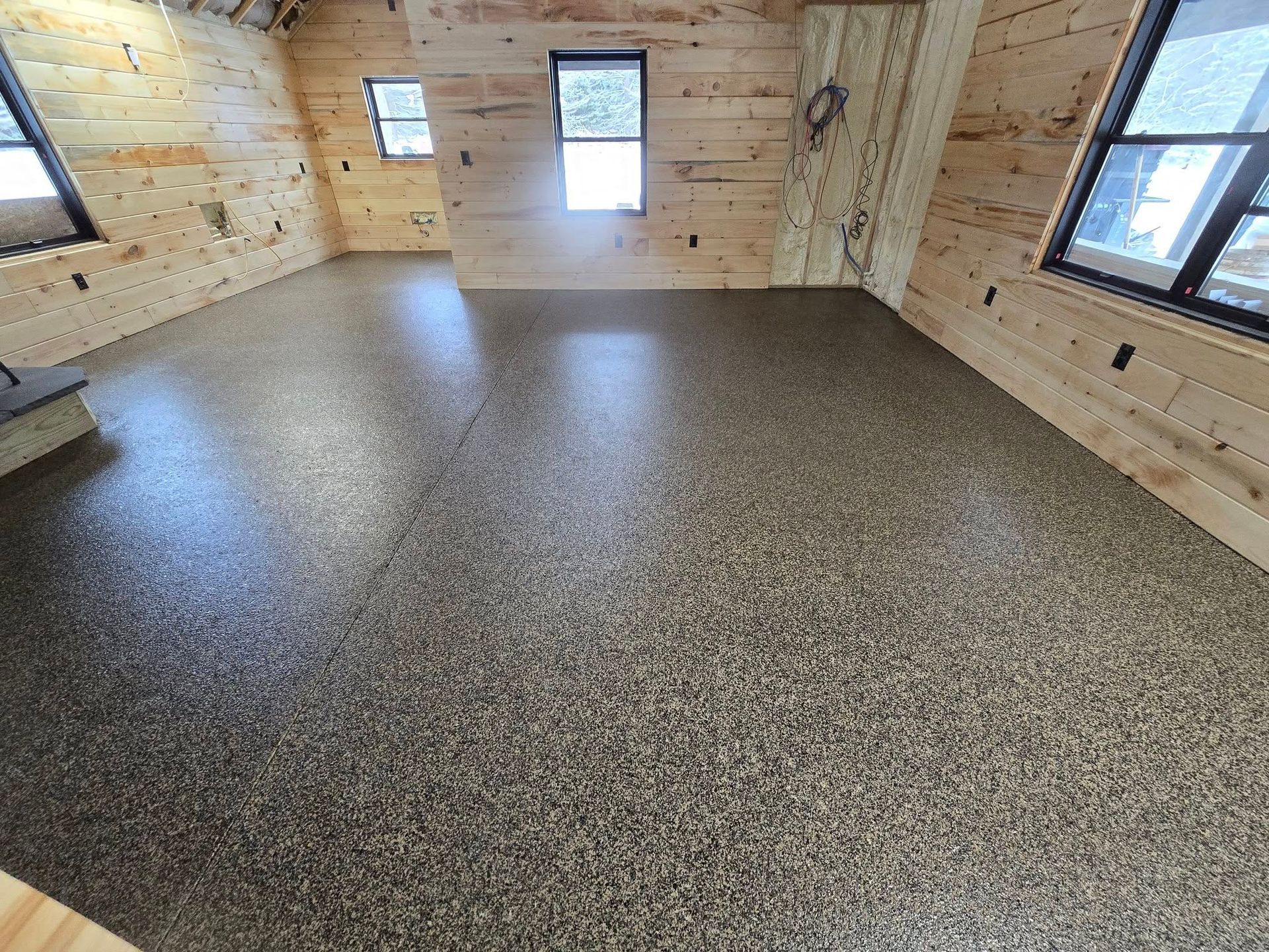 A large room with a concrete floor and wooden walls.