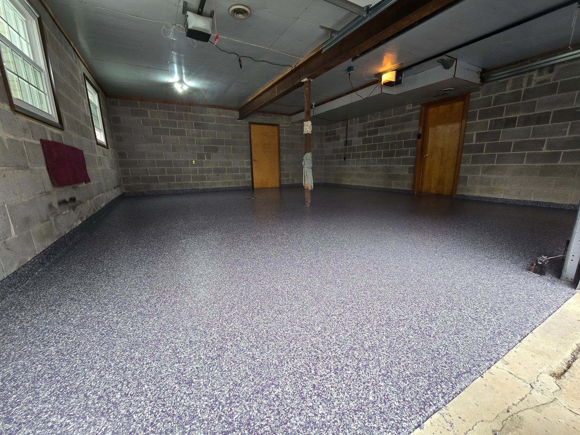 A garage with a purple floor and a brick wall.