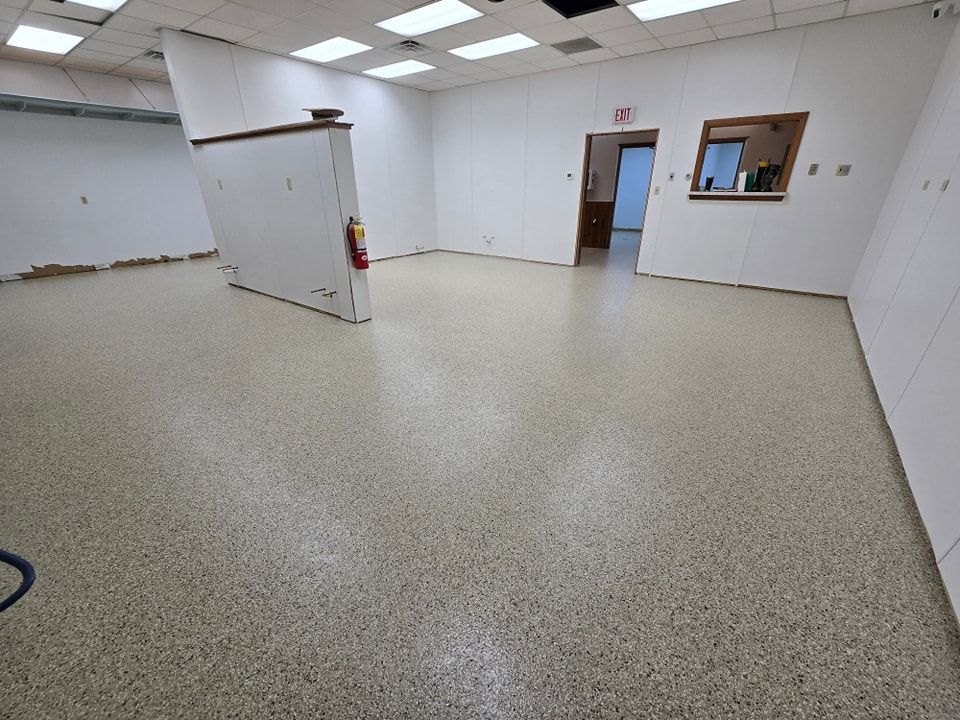 An empty room with a concrete floor and white walls.