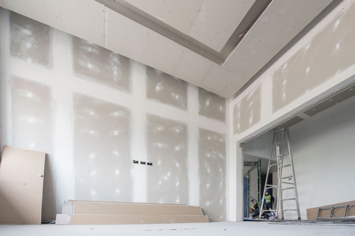 Room under construction with drywall on walls and ceiling, unfinished.