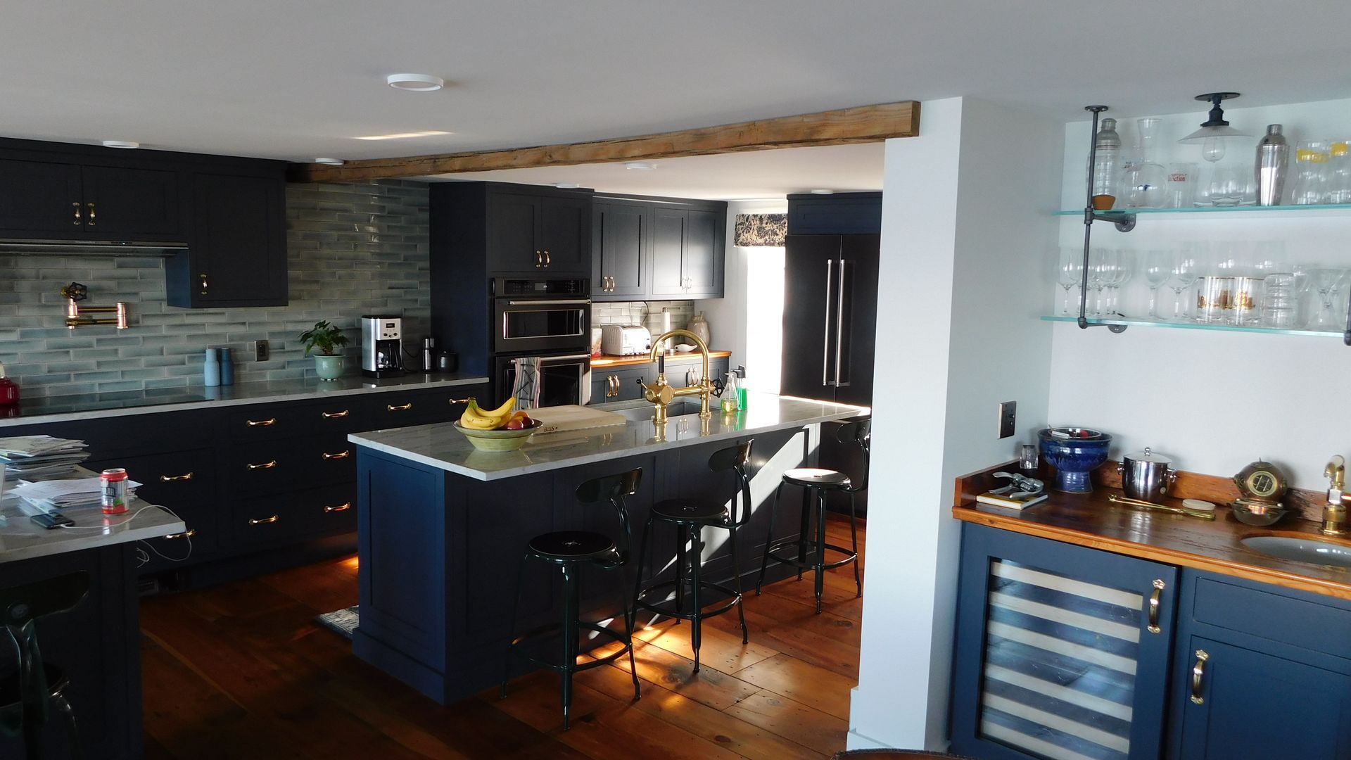 Modern kitchen with black cabinets, a central island, and blue sideboard in a bright open space