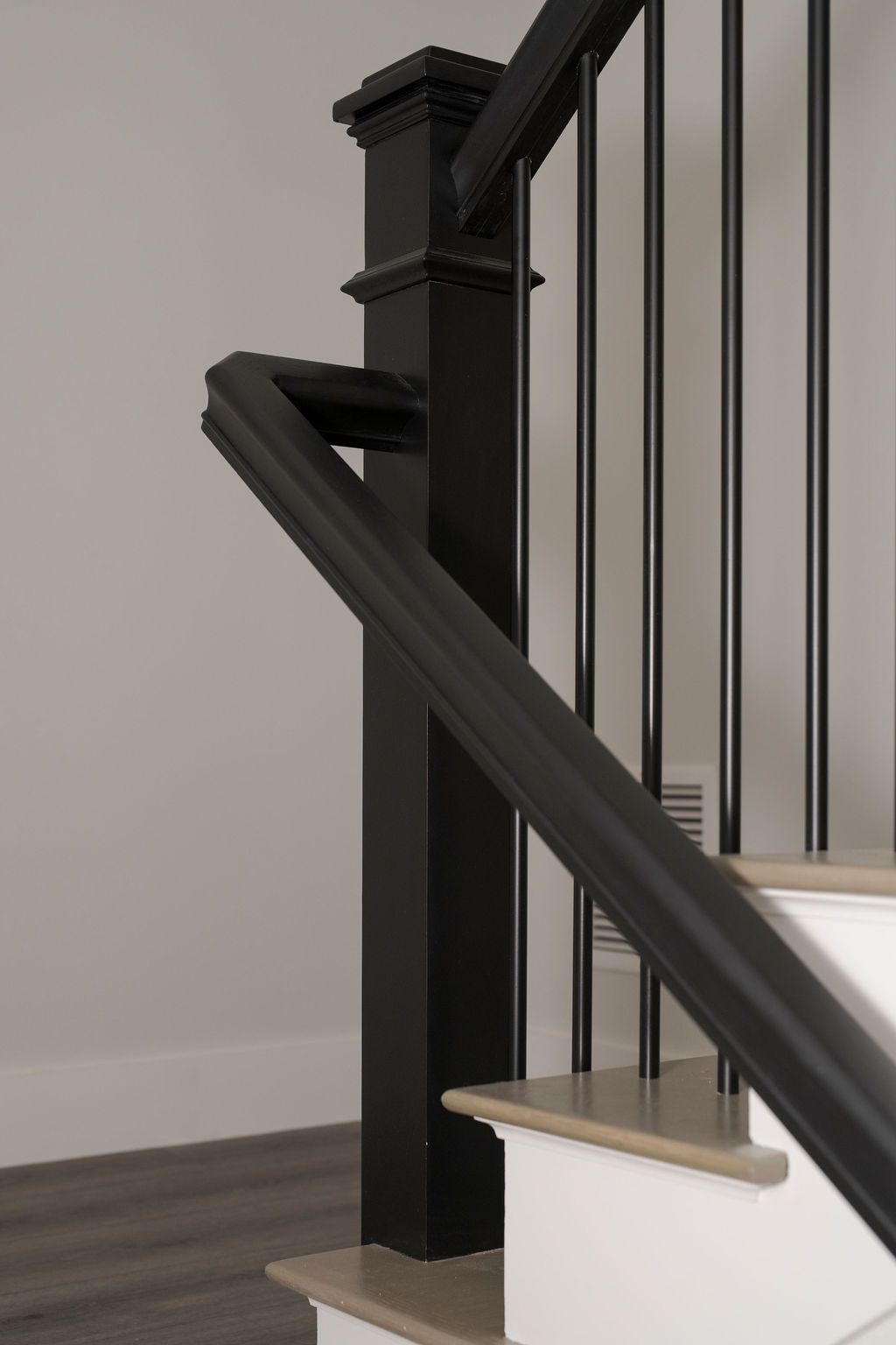 Black staircase railing beside beige steps in a modern home