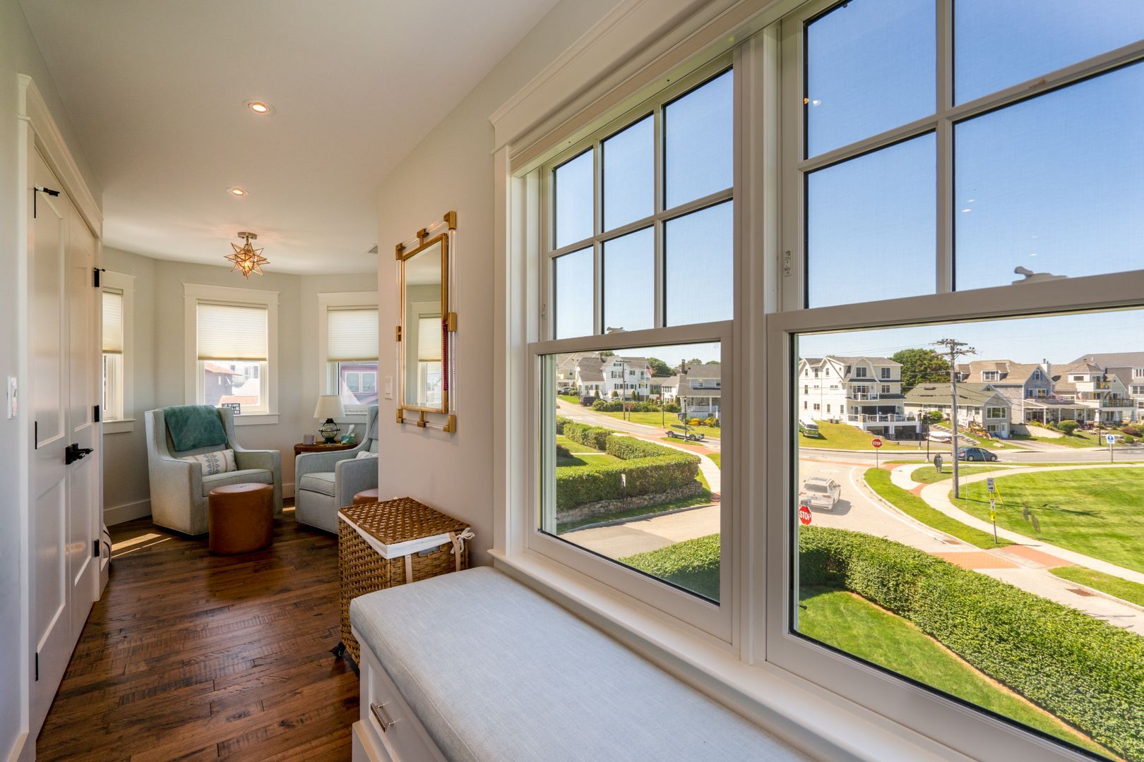 Bright hallway with large windows overlooking a landscaped apartment courtyard and buildings.