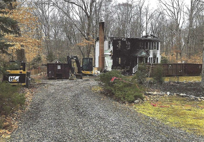 A large house is being demolished in the middle of a forest.