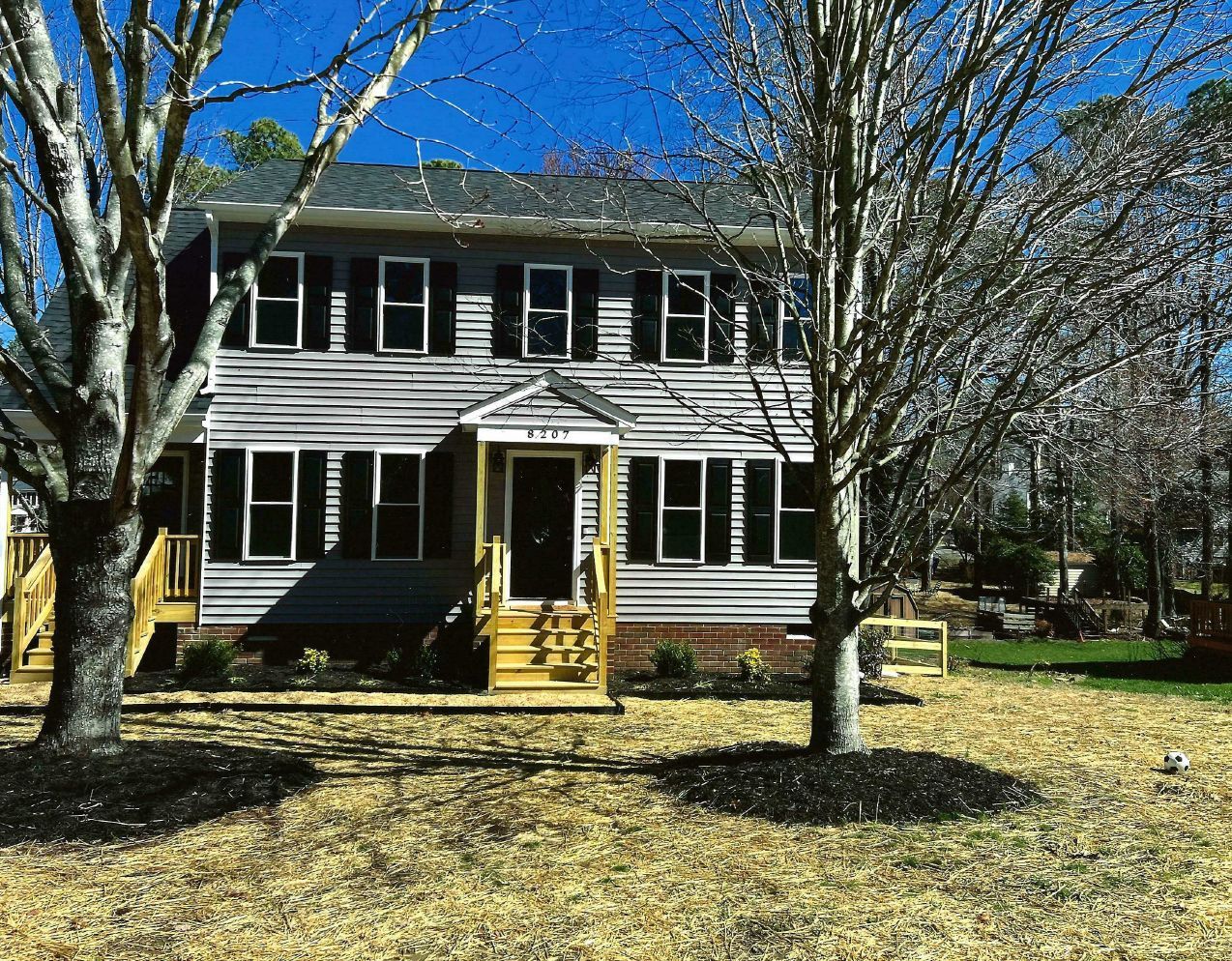 A house with a lot of windows and trees in front of it