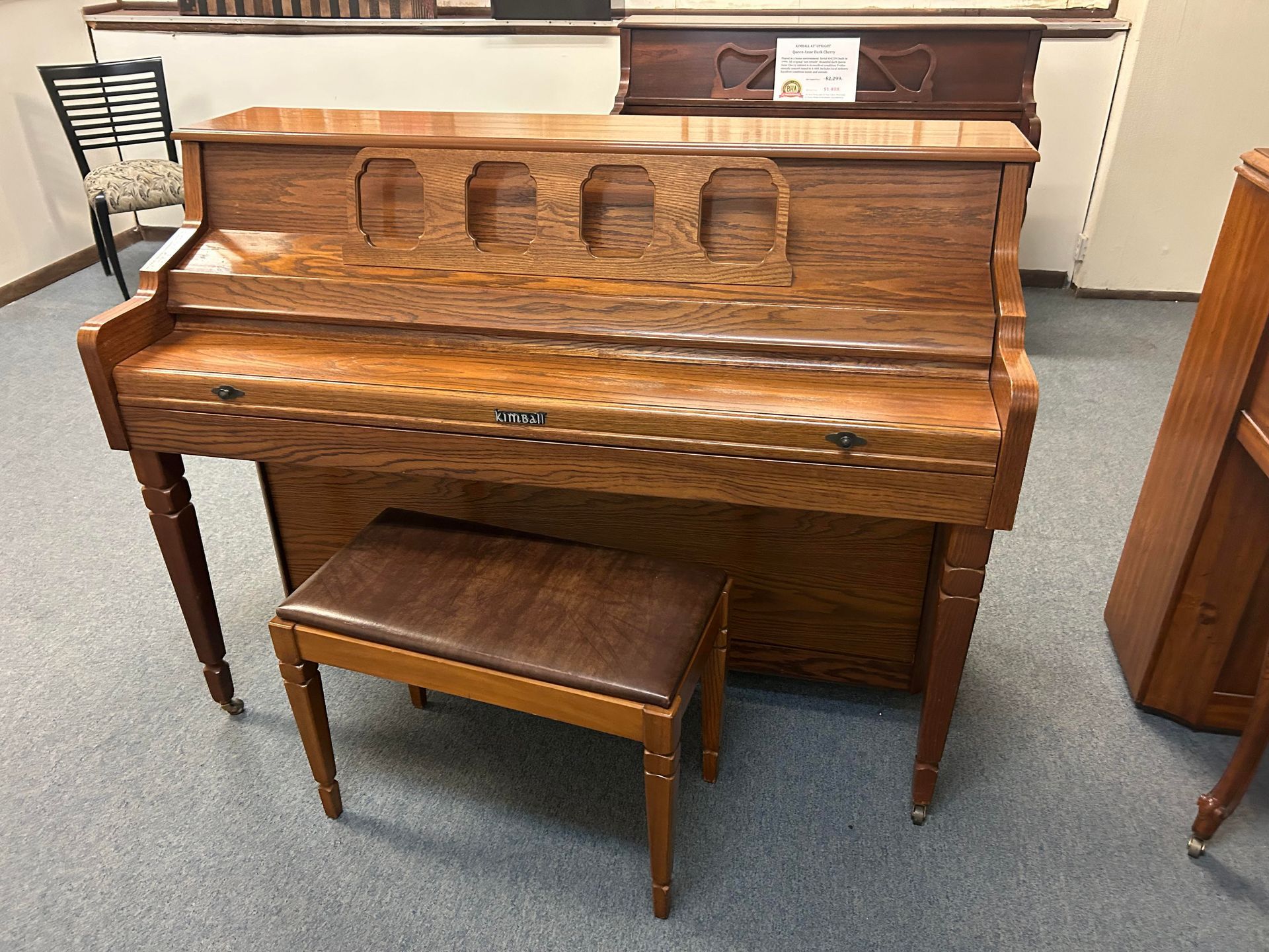 A wooden piano with a bench next to it in a room.