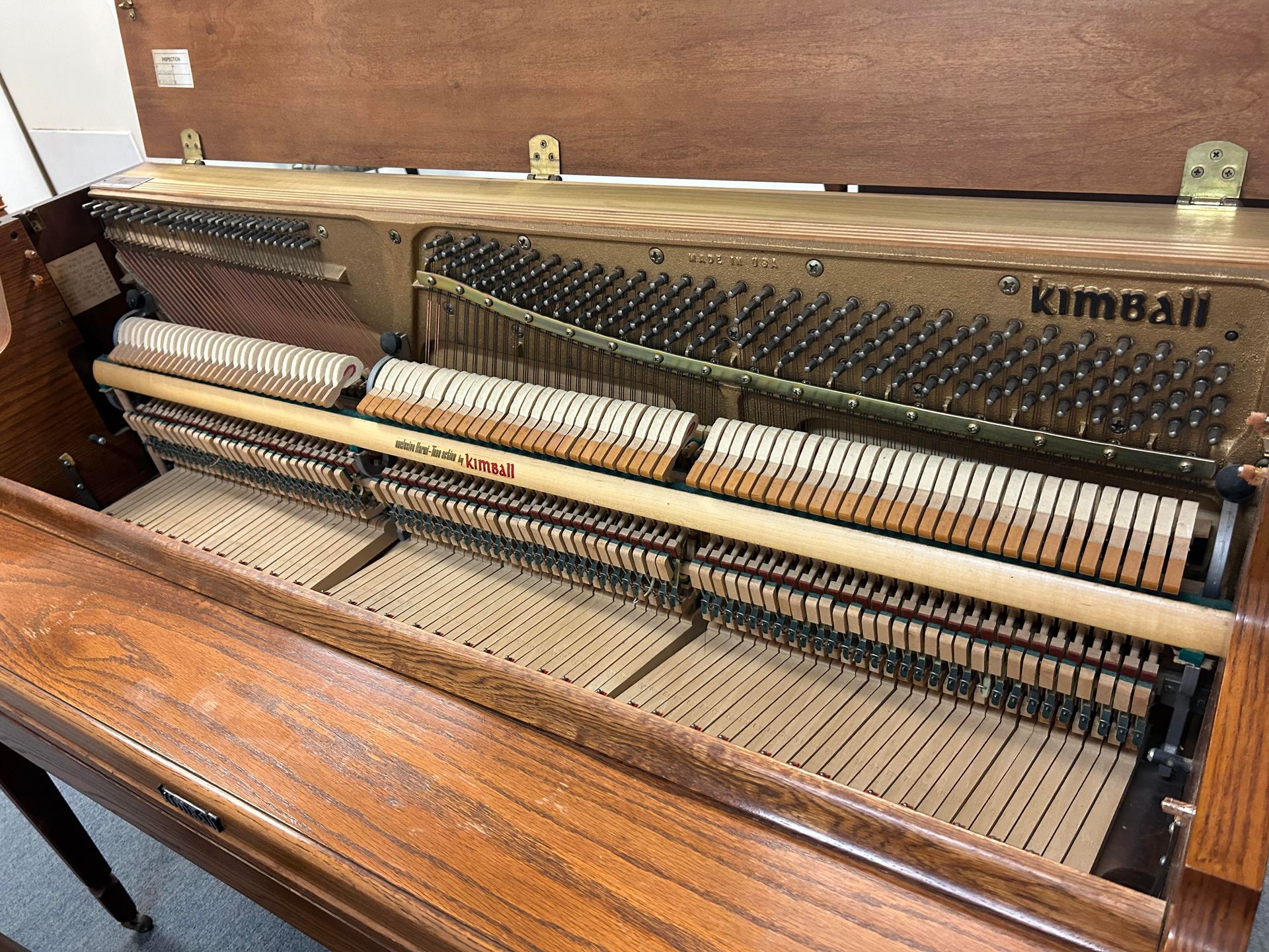 A close up of the inside of a piano with the lid open.