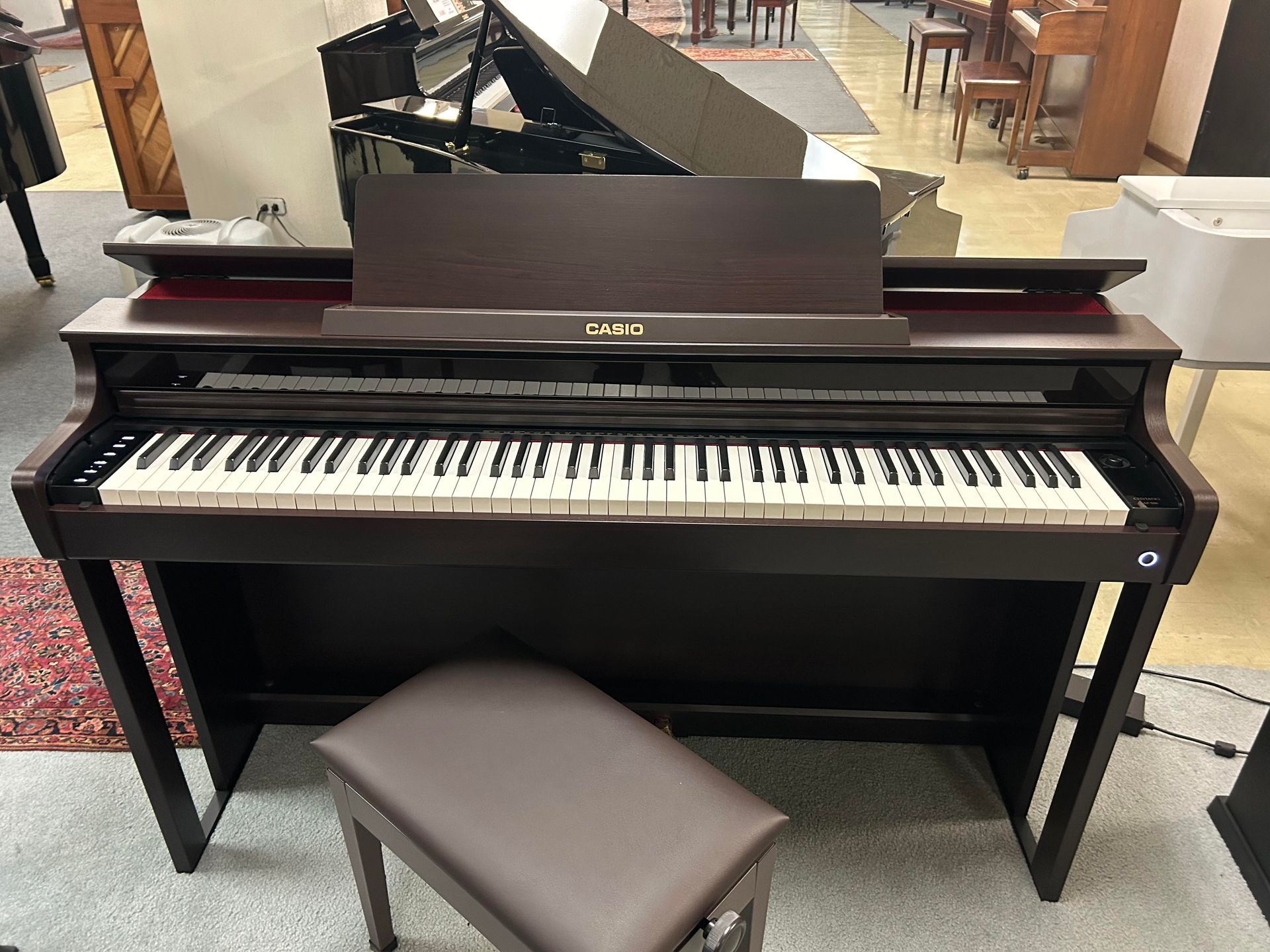 A piano with a stool next to it in a room.