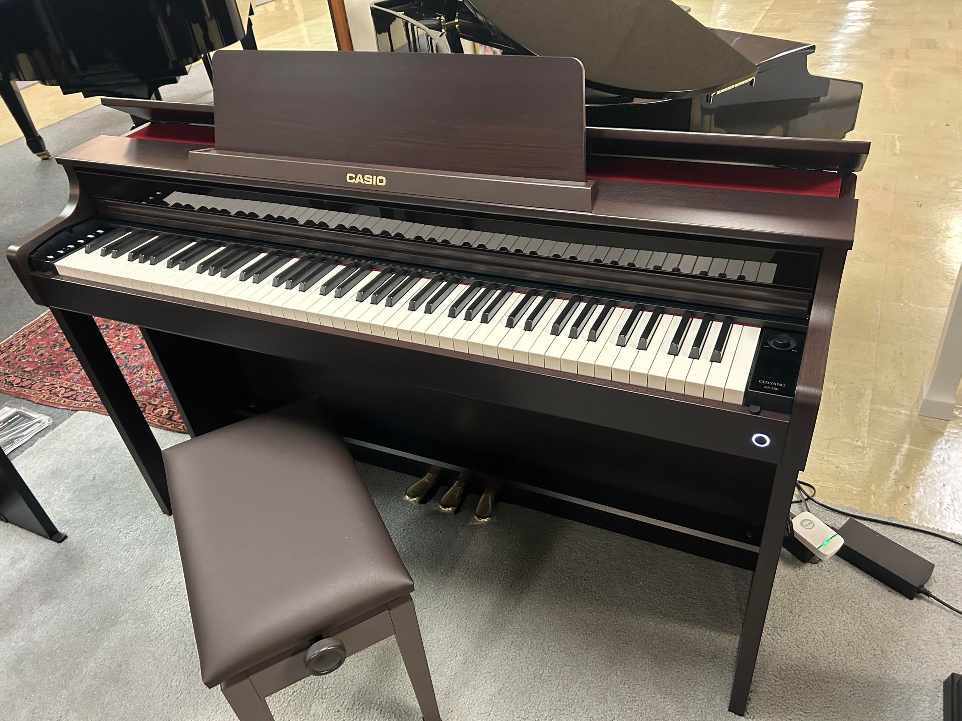 A piano with a stool next to it in a room.