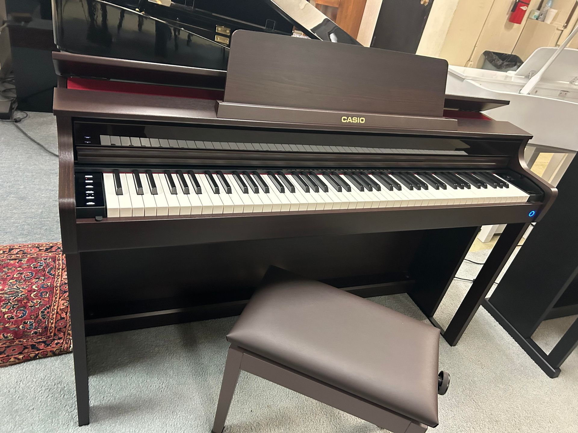 A piano with a stool next to it in a room.