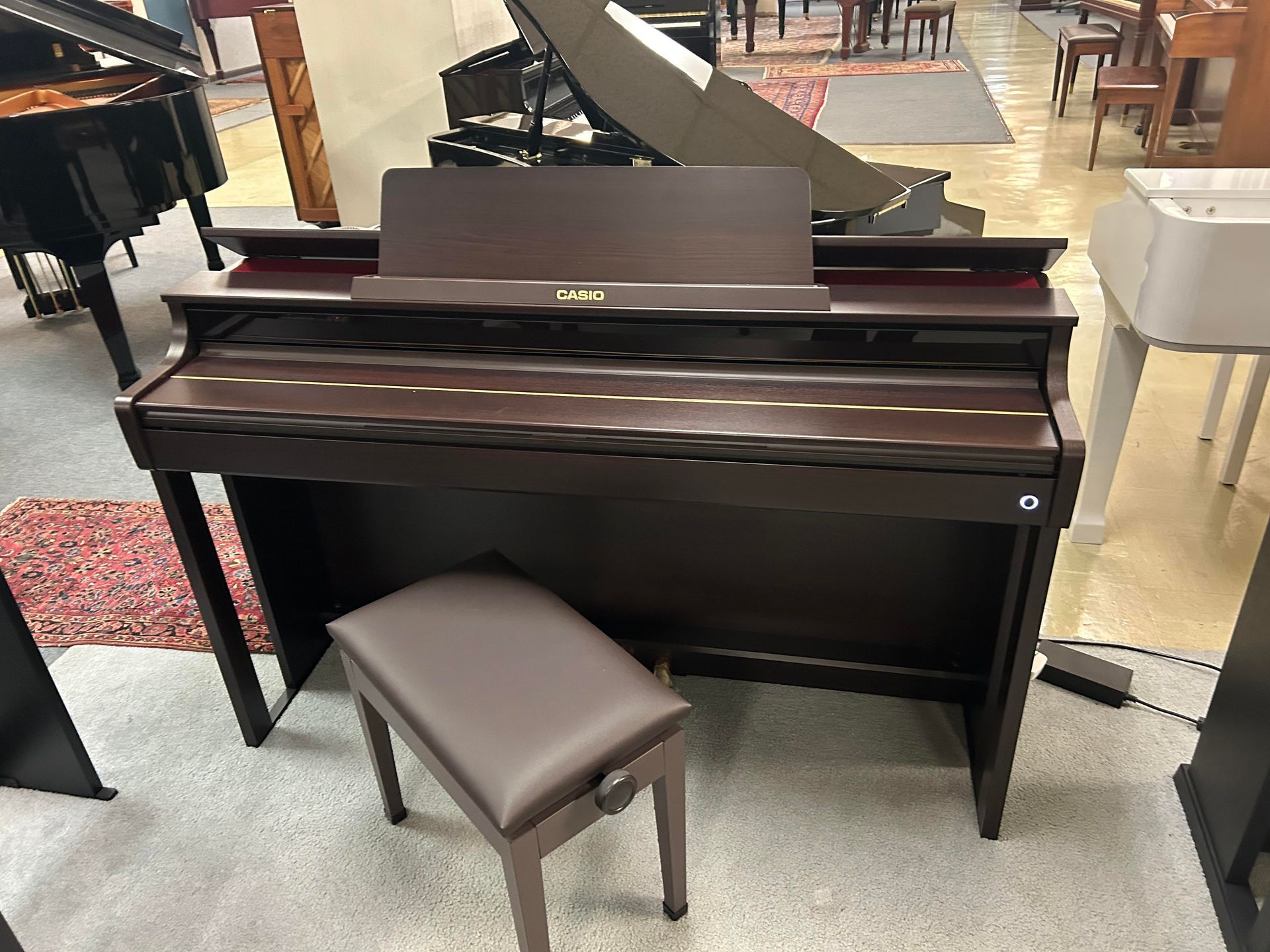 A piano with a stool next to it in a room.