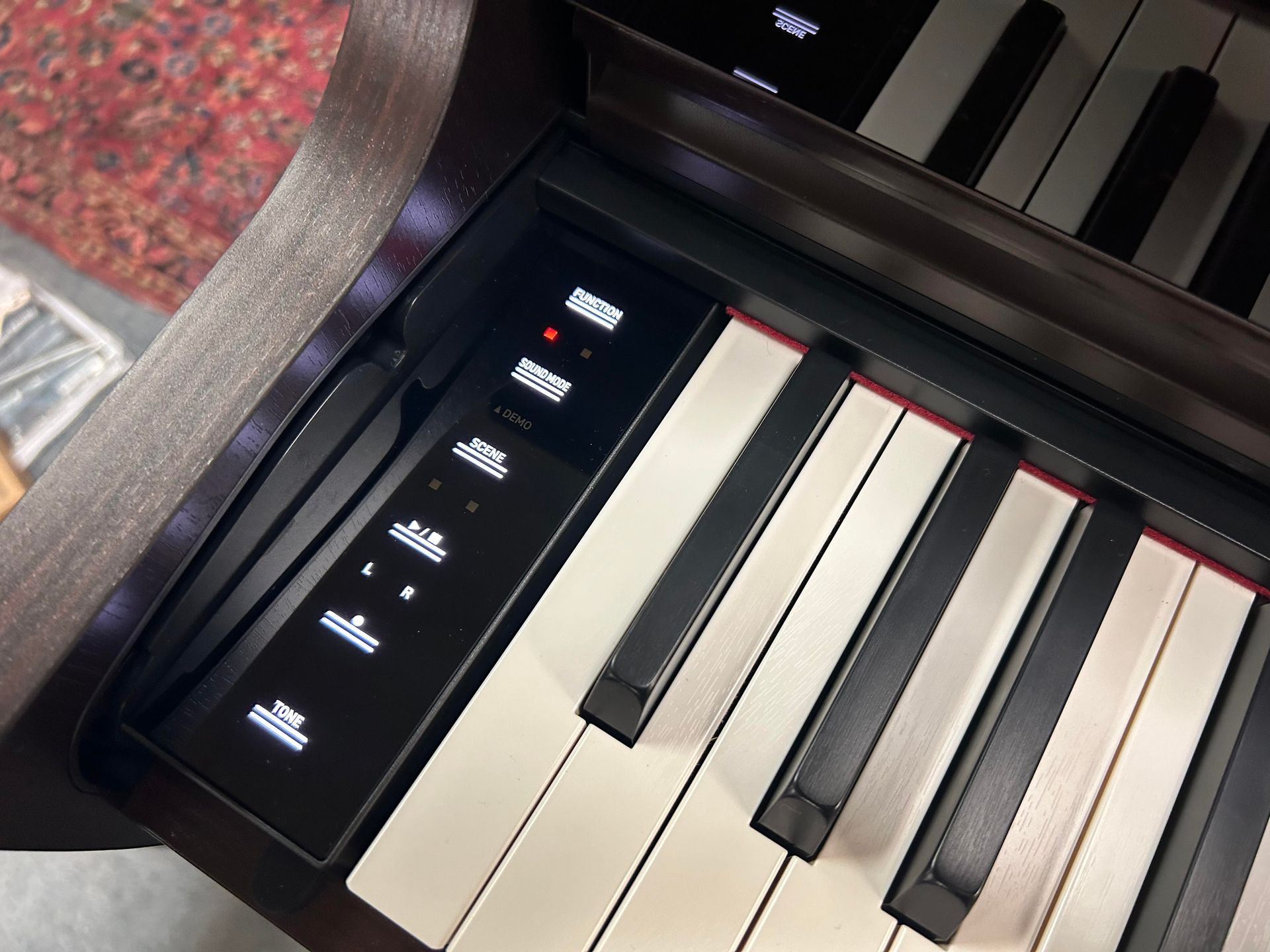 A close up of a piano keyboard with a remote control