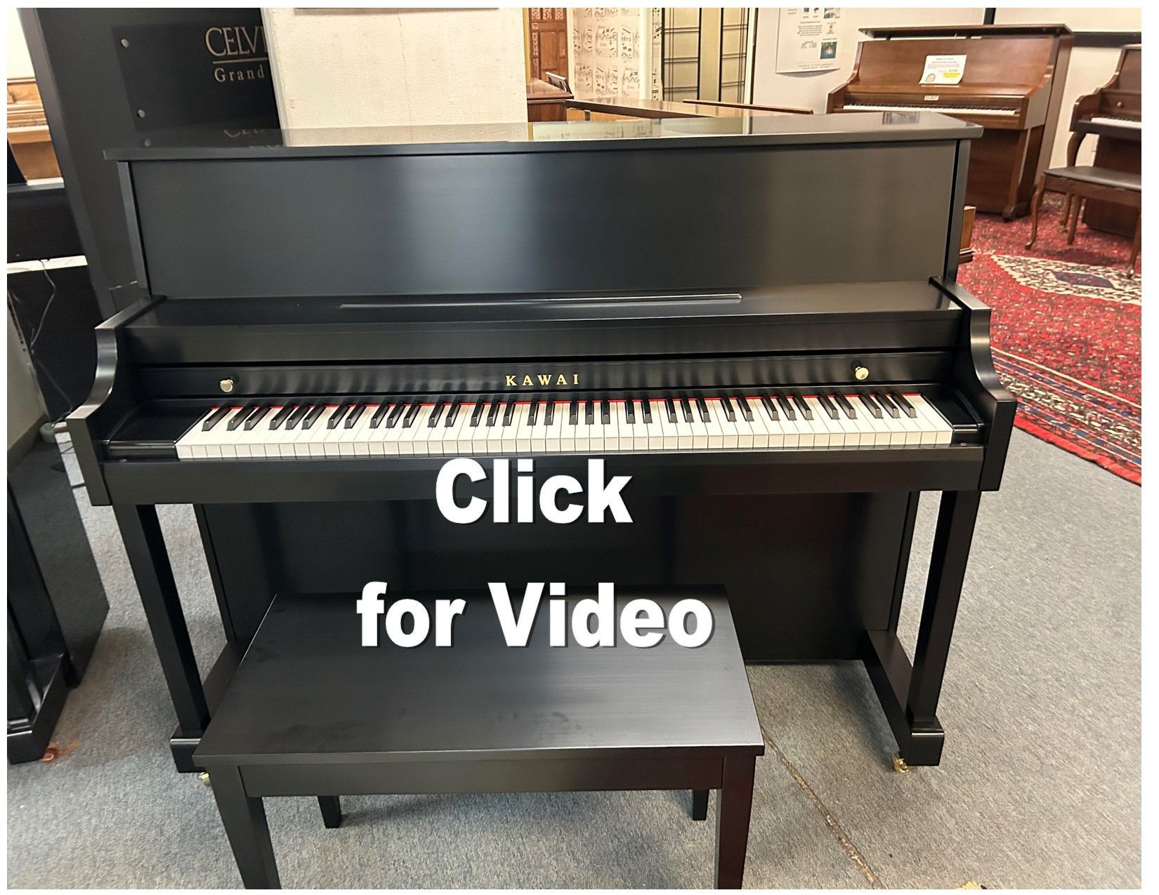 Black Kawai upright piano with bench, indoors.