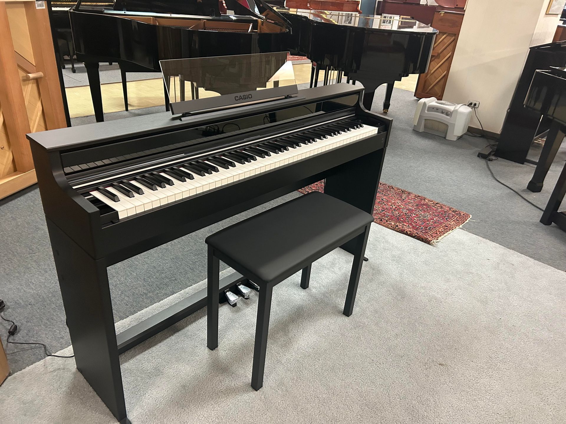 A piano with a bench next to it in a room.