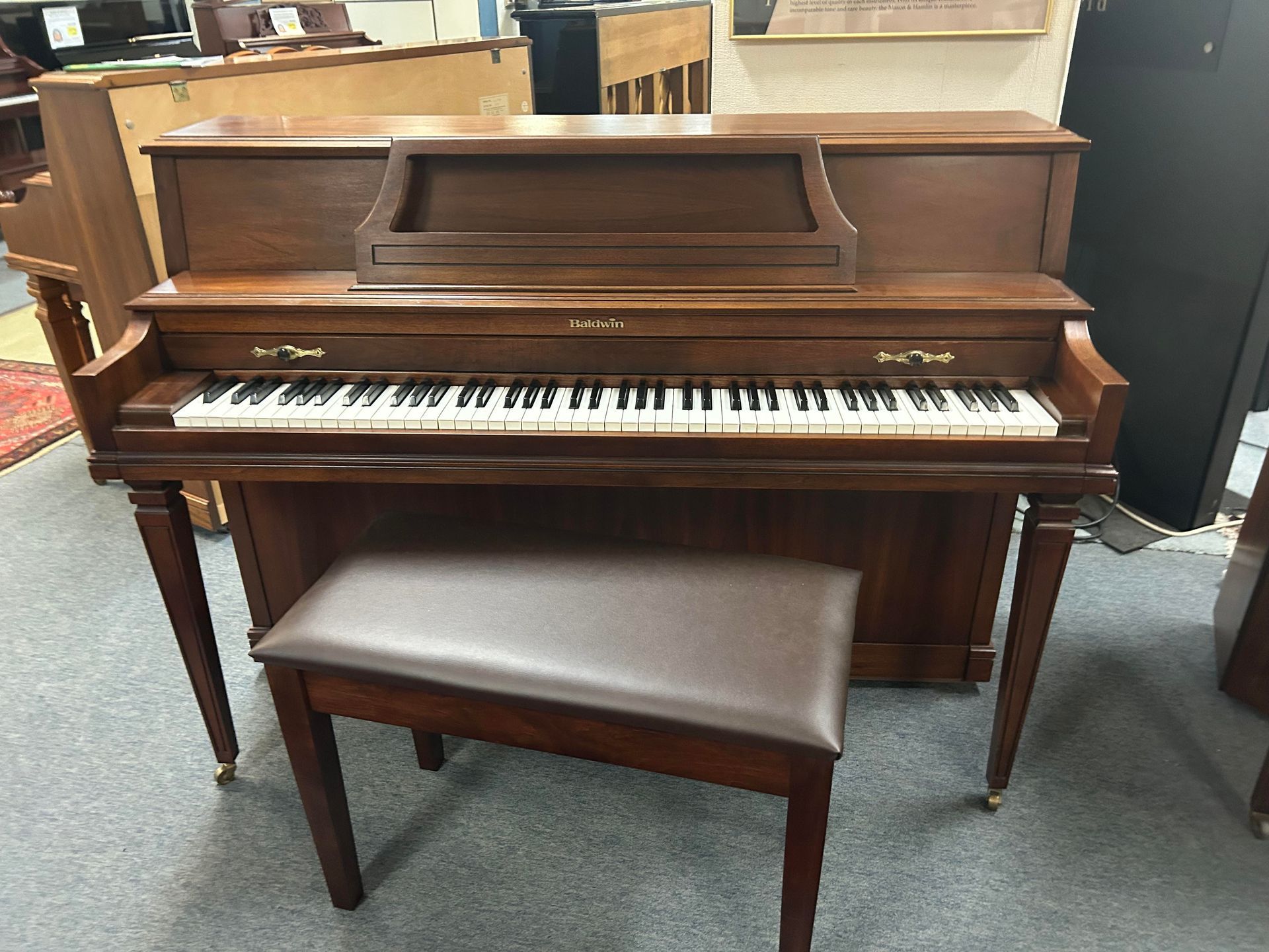 A piano with a bench next to it in a room