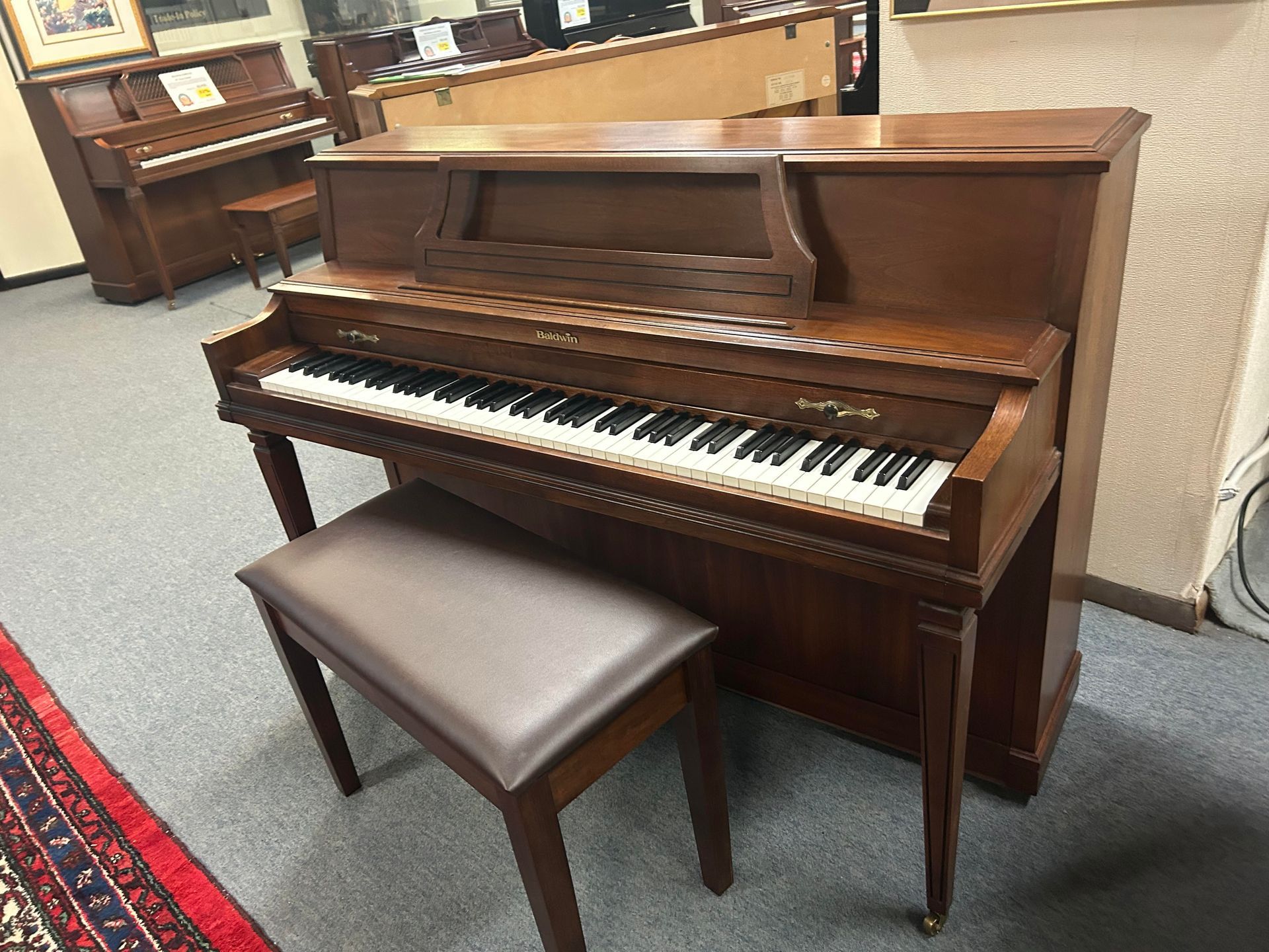A piano with a bench next to it in a room.